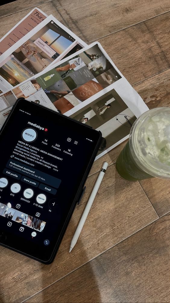 An iPad showing an Instagram profile, next to printed social post layouts